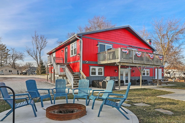 rear view of property with an outdoor fire pit, french doors, and a patio