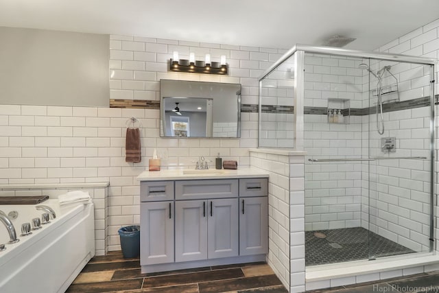 bathroom with separate shower and tub, vanity, ceiling fan, hardwood / wood-style floors, and decorative backsplash