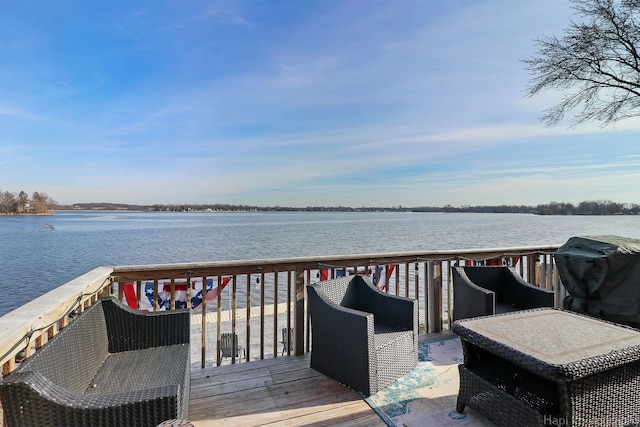 wooden terrace with area for grilling and a water view