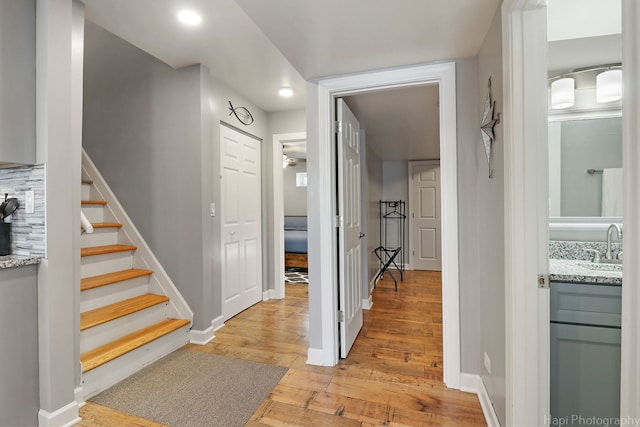 corridor with sink and light hardwood / wood-style flooring