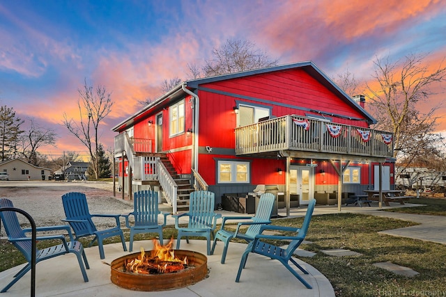 back house at dusk with an outdoor fire pit and a patio