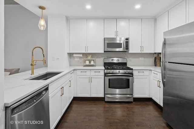 kitchen featuring white cabinetry, appliances with stainless steel finishes, sink, and decorative light fixtures