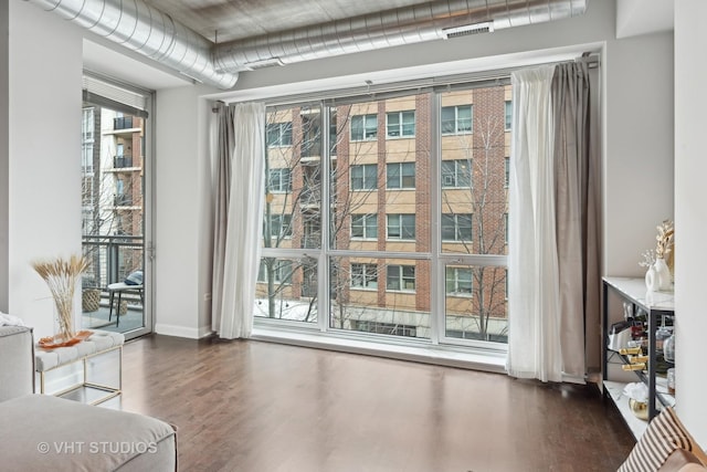 living area with a healthy amount of sunlight and dark hardwood / wood-style flooring