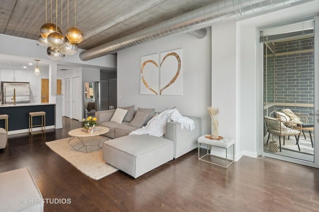 living room featuring a notable chandelier and dark hardwood / wood-style flooring