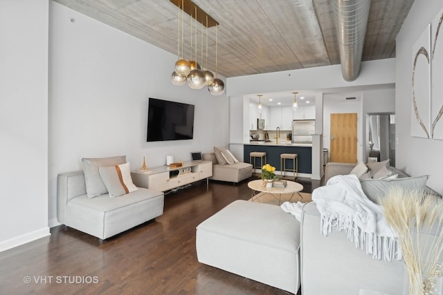 living room with dark hardwood / wood-style floors, sink, and a chandelier