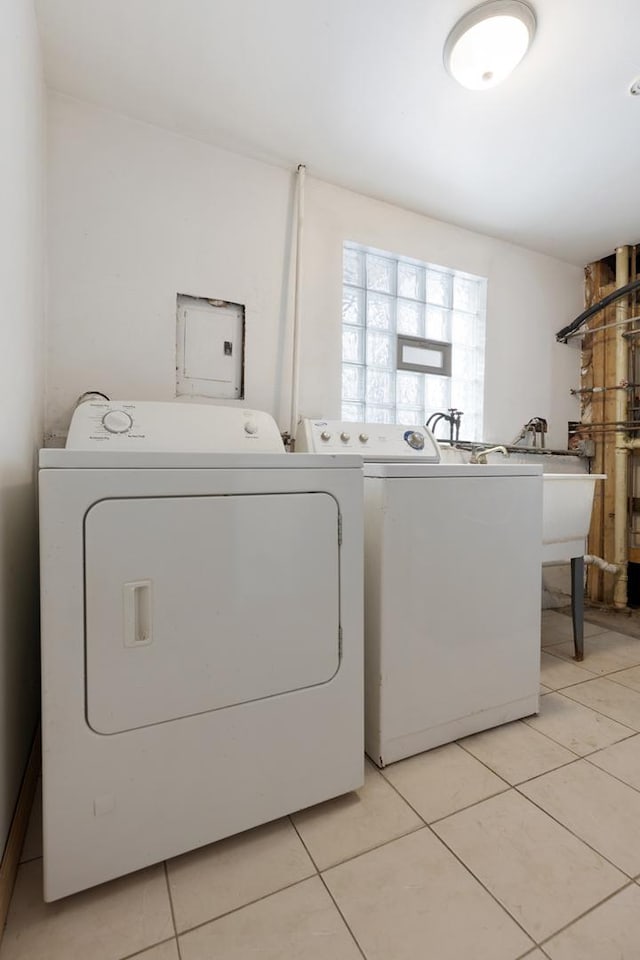 laundry area featuring electric panel, independent washer and dryer, and light tile patterned floors