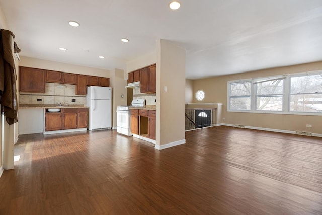 kitchen with white appliances, dark wood-type flooring, and tasteful backsplash