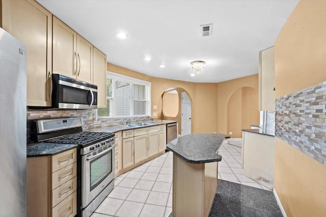 kitchen with stainless steel appliances, light tile patterned flooring, tasteful backsplash, and sink