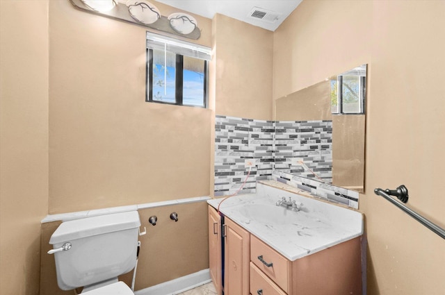 bathroom featuring toilet, backsplash, and vanity