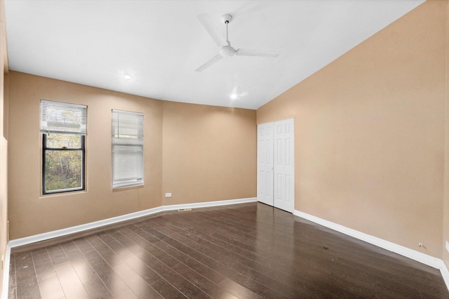 unfurnished room with ceiling fan, vaulted ceiling, and dark wood-type flooring