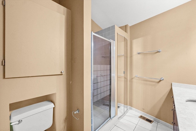 bathroom featuring toilet, tile patterned flooring, vanity, and a shower with shower door