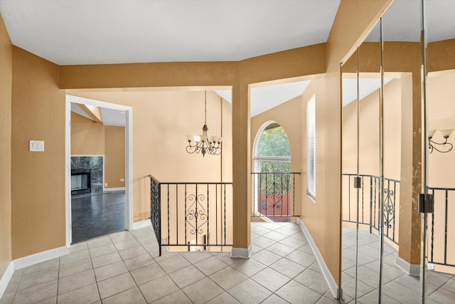 corridor with light tile patterned flooring and a chandelier