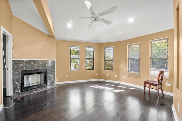 unfurnished living room featuring a tile fireplace, ceiling fan, vaulted ceiling, and dark hardwood / wood-style floors