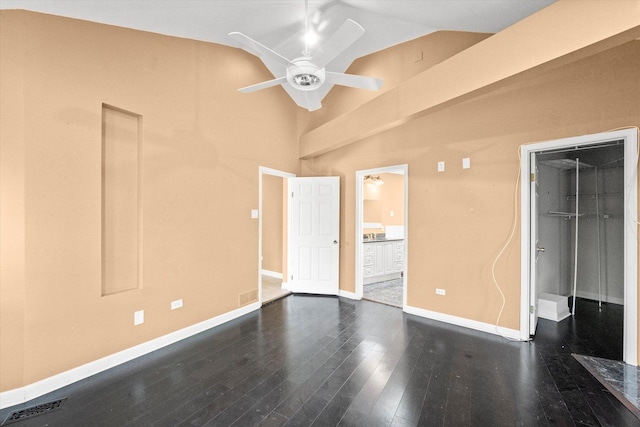 unfurnished bedroom with vaulted ceiling, ensuite bathroom, dark wood-type flooring, and ceiling fan