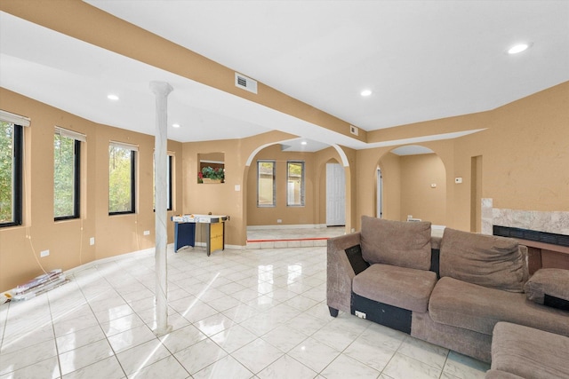 tiled living room featuring a premium fireplace