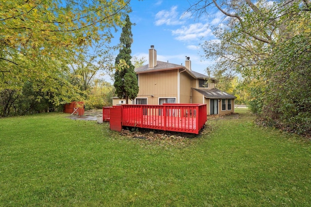 rear view of house with a deck and a lawn