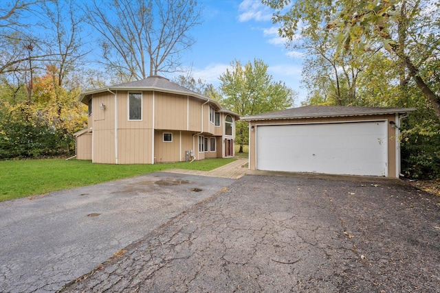 view of side of home with a garage, an outbuilding, and a yard