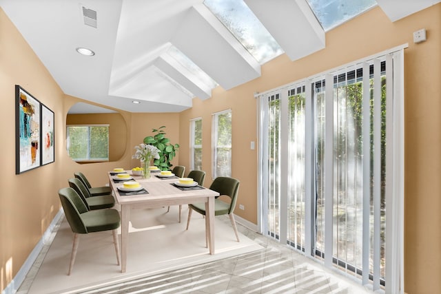 interior space featuring lofted ceiling with skylight