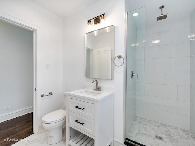 bathroom featuring toilet, an enclosed shower, and vanity