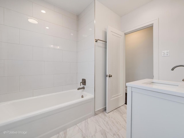 bathroom with tiled shower / bath combo and vanity