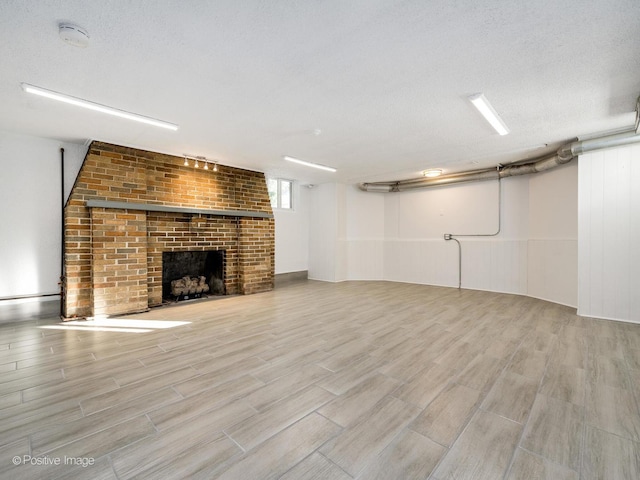 basement with a brick fireplace and a textured ceiling