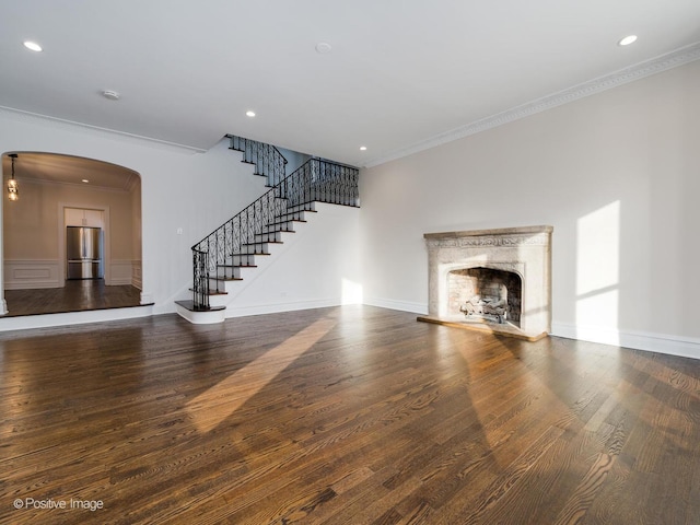 unfurnished living room featuring ornamental molding, dark hardwood / wood-style flooring, and a high end fireplace