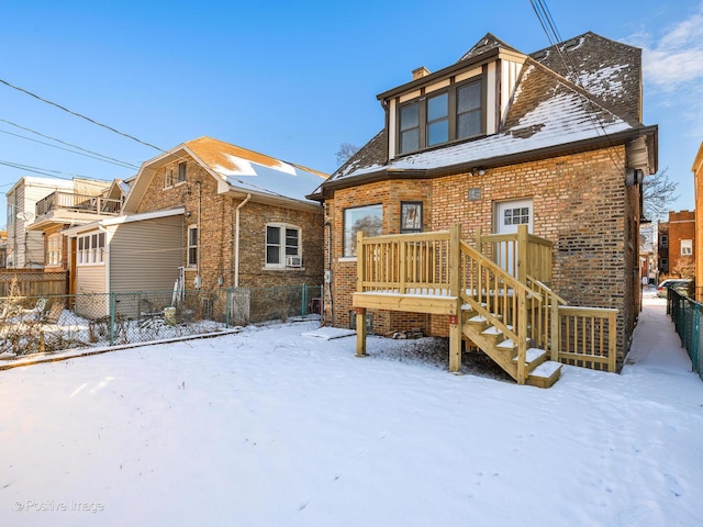 snow covered house featuring a deck