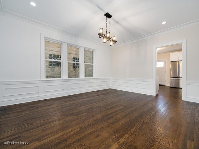 unfurnished room with dark hardwood / wood-style floors, crown molding, and a chandelier