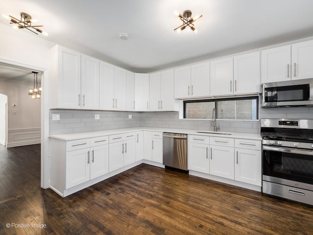 kitchen featuring white cabinets, appliances with stainless steel finishes, dark hardwood / wood-style floors, and sink