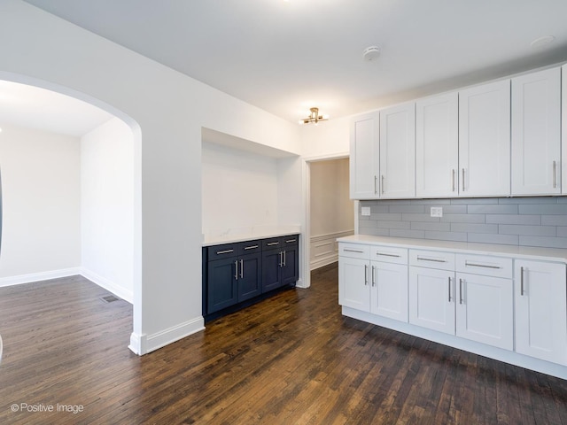 kitchen featuring white cabinets, backsplash, and dark hardwood / wood-style floors