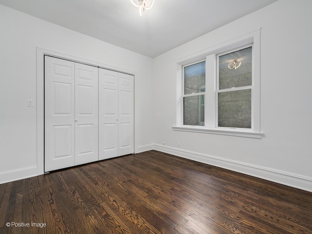 unfurnished bedroom featuring dark wood-type flooring and a closet