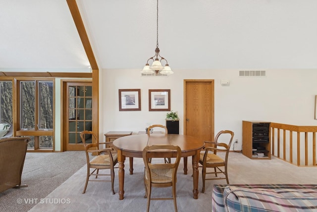 dining area with lofted ceiling, light colored carpet, and a notable chandelier