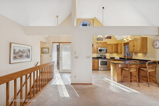 kitchen featuring light tile patterned floors, sink, a breakfast bar area, stainless steel appliances, and kitchen peninsula