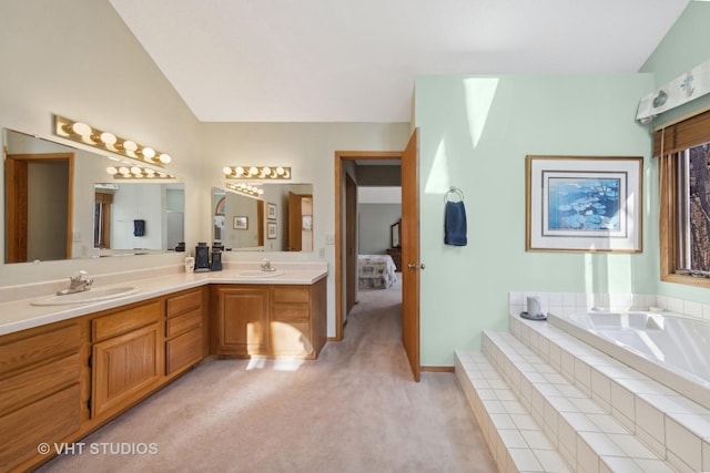 bathroom featuring lofted ceiling, vanity, and tiled tub