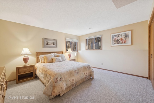 bedroom featuring light carpet and a textured ceiling