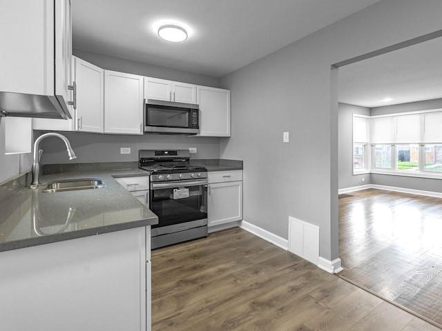 kitchen with sink, stainless steel appliances, white cabinets, and dark hardwood / wood-style floors