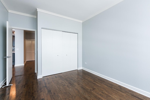 unfurnished bedroom featuring dark wood-type flooring, a closet, and crown molding