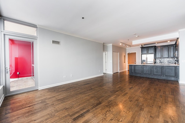 unfurnished living room with dark hardwood / wood-style floors and rail lighting