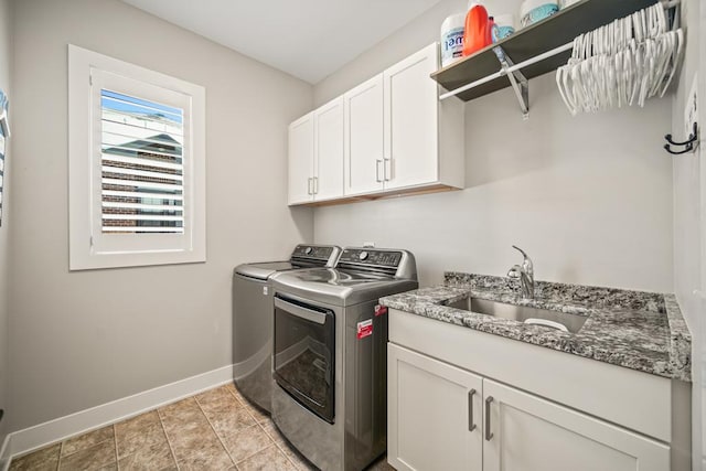 laundry area with sink, washer and clothes dryer, light tile patterned floors, and cabinets