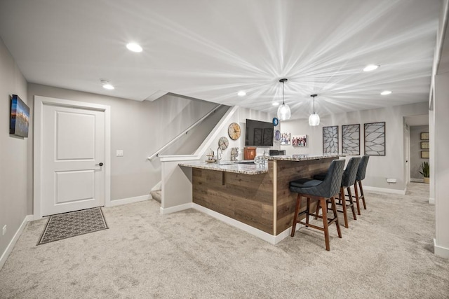 bar with hanging light fixtures, light stone counters, and light colored carpet