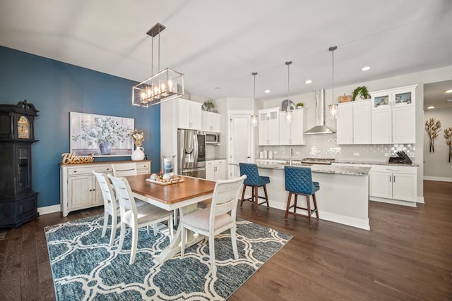 dining room featuring dark wood-type flooring, a notable chandelier, and sink