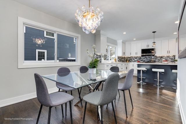 dining room with dark hardwood / wood-style flooring and a chandelier