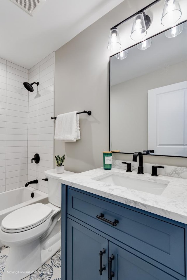 full bathroom with vanity, tile patterned floors, tiled shower / bath combo, and toilet