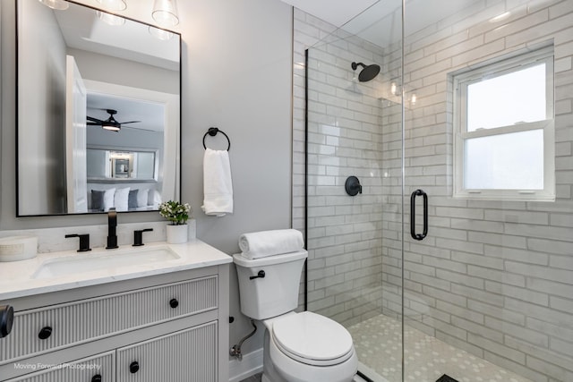 bathroom featuring toilet, ceiling fan, walk in shower, and vanity