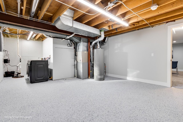 basement with washing machine and dryer, heating unit, and gas water heater