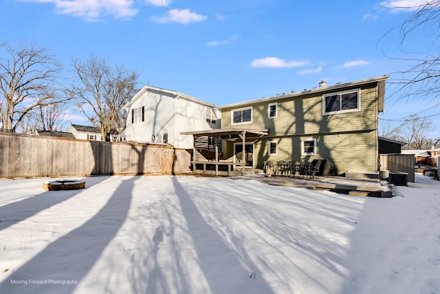 snow covered property with a deck and a fire pit