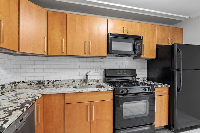 kitchen featuring light stone countertops, black appliances, tile patterned flooring, tasteful backsplash, and sink