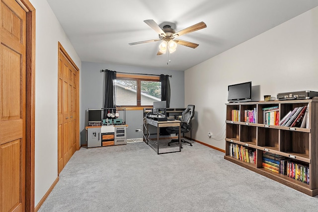 carpeted office space with ceiling fan