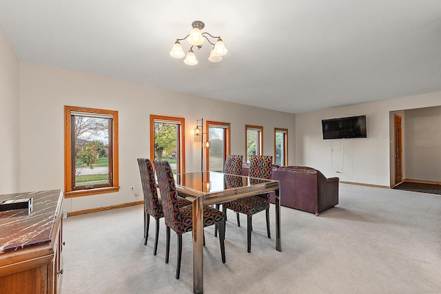 carpeted dining room with an inviting chandelier and plenty of natural light