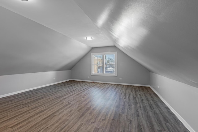 bonus room featuring lofted ceiling, a textured ceiling, and dark hardwood / wood-style flooring